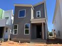 Modern gray two-story home with white window trim and a minimalist design in a construction zone at 101 Parkland Dr, Pittsboro, NC 27312