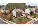 Aerial view of a brick home with manicured lawn, trees, driveway, and two car garage at 1046 Upchurch Farm Ln, Cary, NC 27519