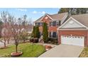 Well-maintained two-story brick house with a green lawn, driveway, and two-car garage at 1046 Upchurch Farm Ln, Cary, NC 27519