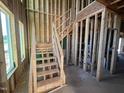 Interior framing of a new construction home, showcasing the staircase and wiring at 107 Parkland Dr, Pittsboro, NC 27312