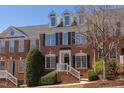 Beautiful brick townhouse featuring black shutters and landscaped front entrance at 107 Westside Dr, Chapel Hill, NC 27516