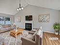 Bright living room featuring neutral decor, fireplace, vaulted ceiling, and comfortable furnishings at 108 New Castle Ct, Youngsville, NC 27596