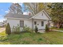 Inviting single story home with a cozy front porch, surrounded by budding trees and green lawn at 1103 Gaston St, Smithfield, NC 27577