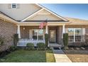 Inviting front porch with an American flag and a white picket fence creates curb appeal at 1176 Andrews Ct, Creedmoor, NC 27522