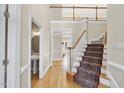 Inviting foyer features hardwood floors, an elegant staircase, and a view of the second-floor balcony at 1301 Merrington Cir, Raleigh, NC 27615