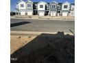 New townhomes along a street, showcasing consistent architectural styles and community development under a sunny sky at 17 Silver Pne Dr, Angier, NC 27501