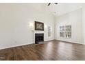 Bright living room with vaulted ceiling, wood flooring, fireplace, and natural light from large windows at 1709 Heisser Ln, Fuquay Varina, NC 27526