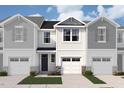 Three townhomes feature varied colors with garages, stone accents, and manicured lawns against a partly cloudy sky at 18 Twin Birch Dr, Angier, NC 27501