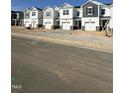 A row of new townhomes line the street with various color accents and front-entry garages, showing a growing community at 18 Twin Birch Dr, Angier, NC 27501