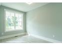 Bright bedroom featuring wood-look floors, white trim, and a large window offering scenic views at 1805 Bright Lantern Way, Wendell, NC 27591