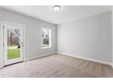 Bright bedroom with neutral carpet, large window offering a view, and a door leading to the outside at 1917 Fishamble St, Fuquay Varina, NC 27526