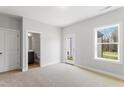 Cozy bedroom featuring plush carpet, natural light from a window and door, with attached bathroom access at 1917 Fishamble St, Fuquay Varina, NC 27526