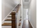 Elegant staircase features hardwood treads, white risers, and stained wood posts with white railings leading upstairs at 1917 Fishamble St, Fuquay Varina, NC 27526