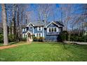 Beautiful two-story home features a well-manicured lawn, brick pathway, and blue siding at 201 Adams Way, Chapel Hill, NC 27516