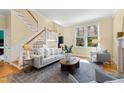 Bright living room with neutral tones, a staircase, and a large window providing ample natural light at 201 Adams Way, Chapel Hill, NC 27516