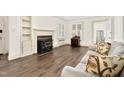 Bright living room featuring a classic fireplace, built-in shelving, and comfortable seating on hardwood floors at 2120 Cokey Rd, Rocky Mount, NC 27801