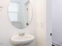 Powder bathroom with oval mirror and pedestal sink with chrome fixtures at 22 Twin Birch Dr, Angier, NC 27501