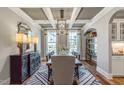 Formal dining room boasts coffered ceilings, hardwood floors, and ample natural light from large windows at 243 Augusta Pond Way # 163, Raleigh, NC 27603