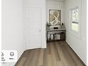 Hallway features wood floors, neutral walls, decor console, and natural light at 269 Beacon Dr, Pittsboro, NC 27312