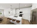 Bright kitchen with white cabinets, stainless steel appliances, island, and pendant lighting at 272 Beacon Dr, Pittsboro, NC 27312