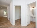 Bright hallway with wood floors showing an open room and a powder room at 280 Beacon Dr, Pittsboro, NC 27312