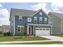 Charming two-story home with blue siding, a red front door, and a white two-car garage at 2801 Landon Ridge Dr, New Hill, NC 27562