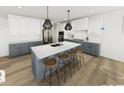 Modern kitchen with stainless steel appliances, white cabinets, gray island and bar stool seating at 304 Beacon Dr, Pittsboro, NC 27312