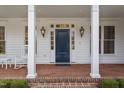 Elegant blue front door framed by white pillars and windows, with sconces and brick steps at 321 Nottingham Dr, Chapel Hill, NC 27517