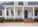 Inviting front porch featuring classic white columns, brick steps, and two rocking chairs at 321 Nottingham Dr, Chapel Hill, NC 27517