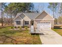 Well-kept single-story home with an attached garage, accessible ramp, manicured landscaping, and a welcoming facade at 35 Wickersham Way, Louisburg, NC 27549