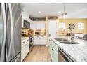 Modern kitchen featuring stainless steel appliances, granite countertops, a stylish faucet, and white cabinetry at 35 Wickersham Way, Louisburg, NC 27549