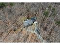 Aerial view of a secluded home nestled among trees, showcasing its roofline and driveway at 3900 Marklyn Pl, Hillsborough, NC 27278