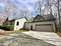 Exterior view of home, displaying a long driveway, attached garage, and a well-maintained lawn at 3900 Marklyn Pl, Hillsborough, NC 27278
