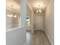 Bright foyer with light wood floors, elegant lighting fixtures, and neutral paint at 396 Hopewell Branch Ct, Smithfield, NC 27577