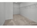 Walk-in closet with carpet flooring, built-in shelving, and ample storage space at 4825 Bristol Meadow Dr, Raleigh, NC 27603