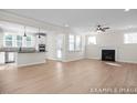 Bright and open living room featuring light hardwood floors, a fireplace, and an attached kitchen with modern appliances at 4825 Bristol Meadow Dr, Raleigh, NC 27603