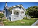 Gray two-story home featuring a welcoming front porch with white railings and brick facade at 508 S Swain St, Raleigh, NC 27601