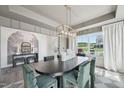 Elegant dining room featuring an oval table, green velvet chairs, modern chandelier, and large window at 556 Contempo Dr # 22, Rolesville, NC 27571