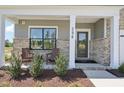 Inviting front porch with chairs, brick accents, and a view of the landscaped front yard at 556 Contempo Dr # 22, Rolesville, NC 27571