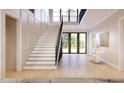 Bright entryway with wooden floors, grand staircase, black railings, and transom windows providing natural light at 5808 Norwood Ridge Dr, Raleigh, NC 27614