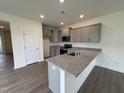 Stylish kitchen features granite counters, gray cabinets, recessed lighting, and stainless steel appliances for a modern appeal at 6401 Granite Quarry Dr, Raleigh, NC 27610