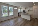 Bright kitchen featuring a central island, white cabinets, and stainless steel appliances at 6403 Granite Quarry Dr, Raleigh, NC 27610