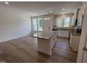 Open-concept kitchen boasts an island with granite countertop and wood-look flooring at 6403 Granite Quarry Dr, Raleigh, NC 27610