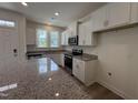 Well-lit kitchen featuring white cabinets, granite countertops and stainless steel appliances at 6403 Granite Quarry Dr, Raleigh, NC 27610