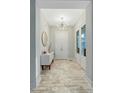 Bright foyer featuring an elegant chandelier and pristine plank flooring at 6609 Truxton Ln, Raleigh, NC 27616