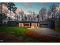 Contemporary home with dark brick exterior, large windows, and manicured lawn at 721 Jones Ferry Rd, Chapel Hill, NC 27516