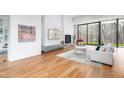 Cozy living room with a fireplace, modern furniture, and large windows with wood views at 721 Jones Ferry Rd, Chapel Hill, NC 27516