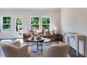 Cozy living room with ample natural light, plush seating, stylish decor, and a view of the landscaped backyard at 803 Windmill Palm Dr, Zebulon, NC 27597