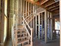 Interior view of wooden framing highlighting the staircase during the construction phase at 95 Parkland Dr, Pittsboro, NC 27312