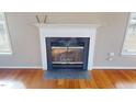 A close up of a fireplace with a white mantle and black surround in a home with hardwood floors at 96 Overlook Rd, Cameron, NC 28326